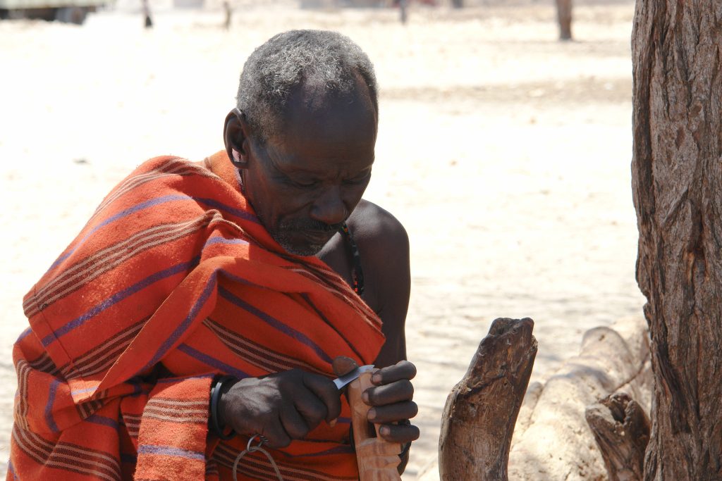 "Samburu Man Carving Wood," by Filiberto Strazzari, licensed under CC attribution 2.0, at https://commons.wikimedia.org/wiki/File:Samburu_man_carving_wood.jpg